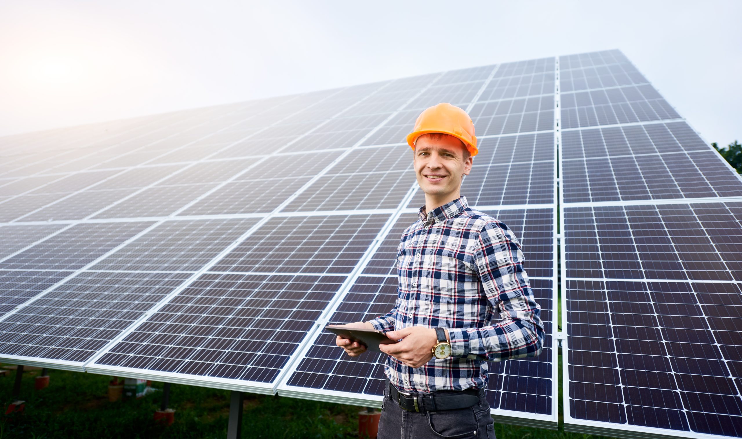 man with tablet and in background solar panels