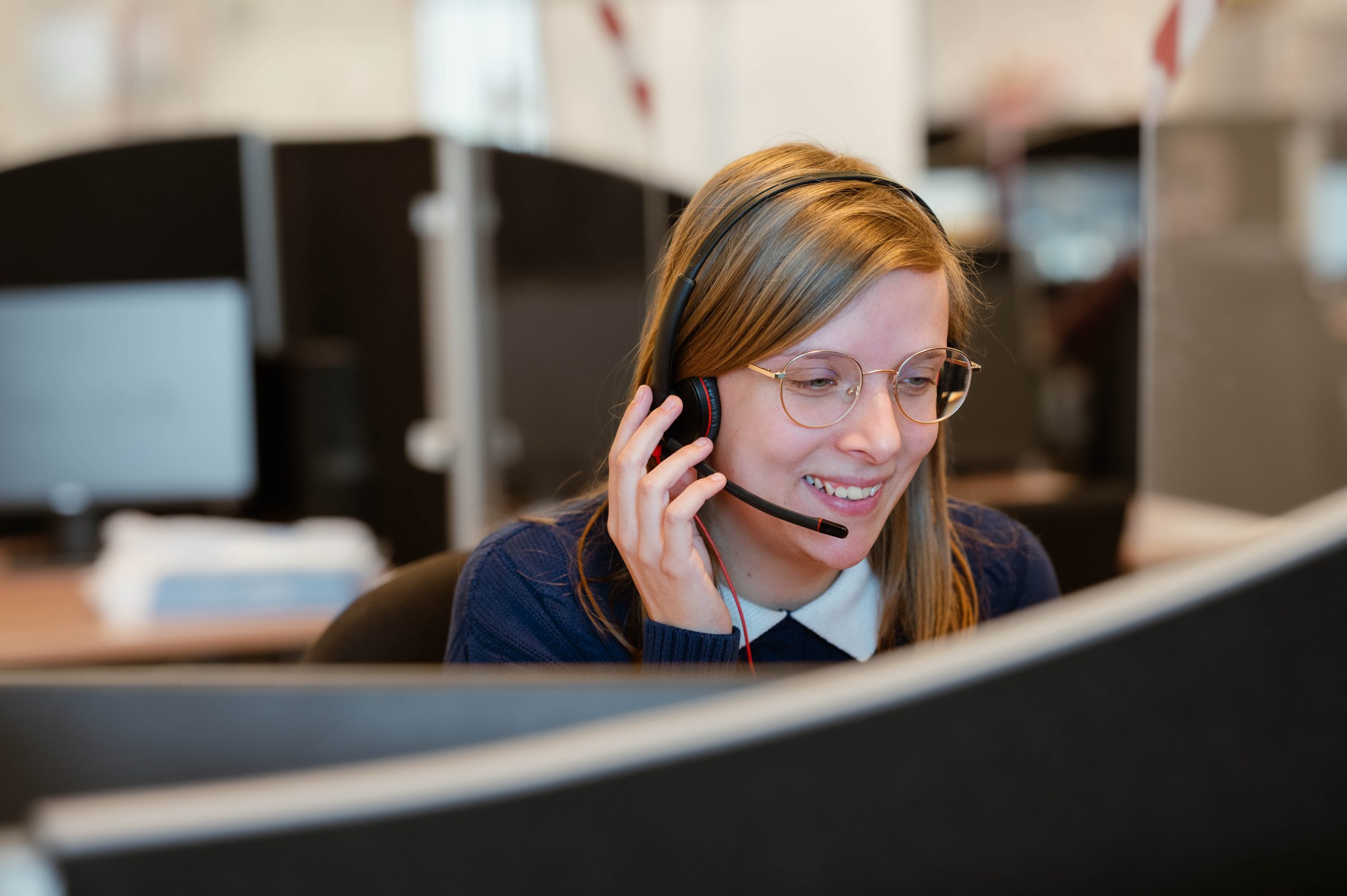 women with a microphone looking to a computer in a helpdesk