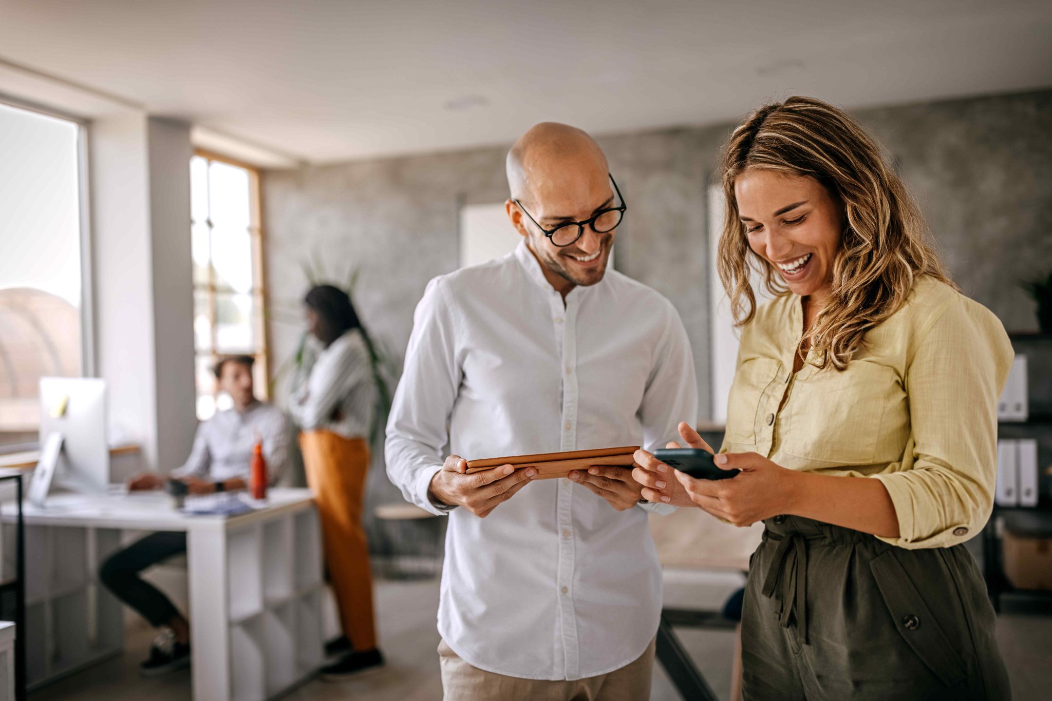 two people looking to a screen and there a two people in the background