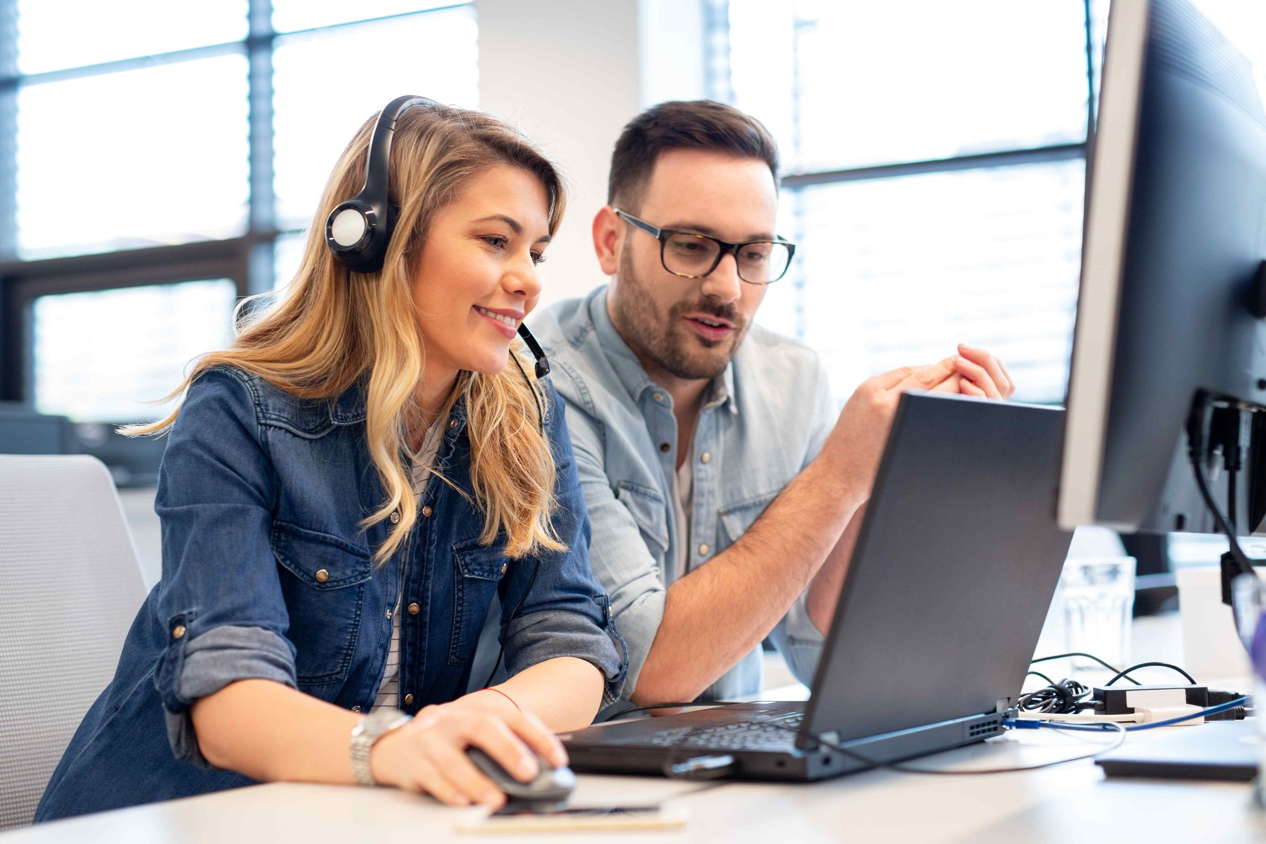 two people looking to a screen in an offshore contact center