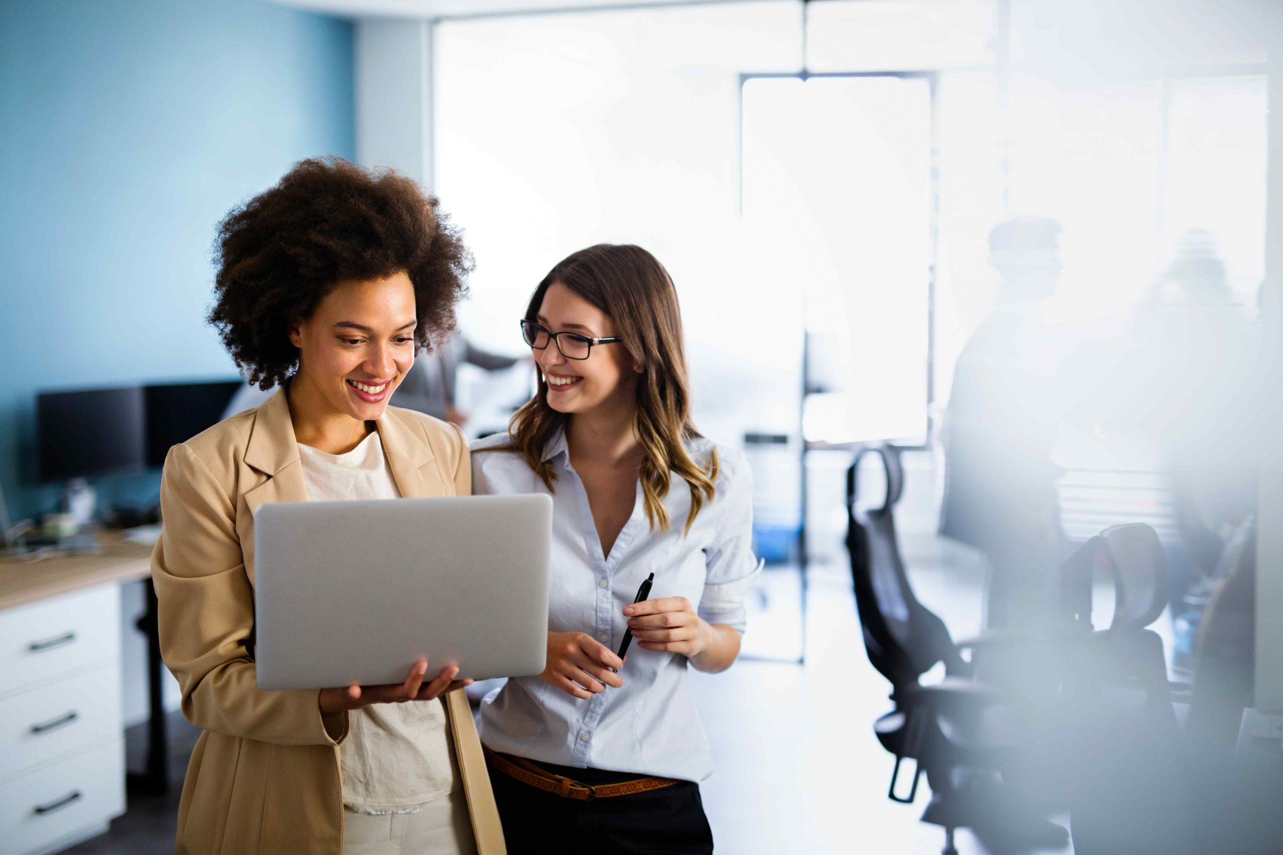 two smiling people with a laptop in a technical helpdesk