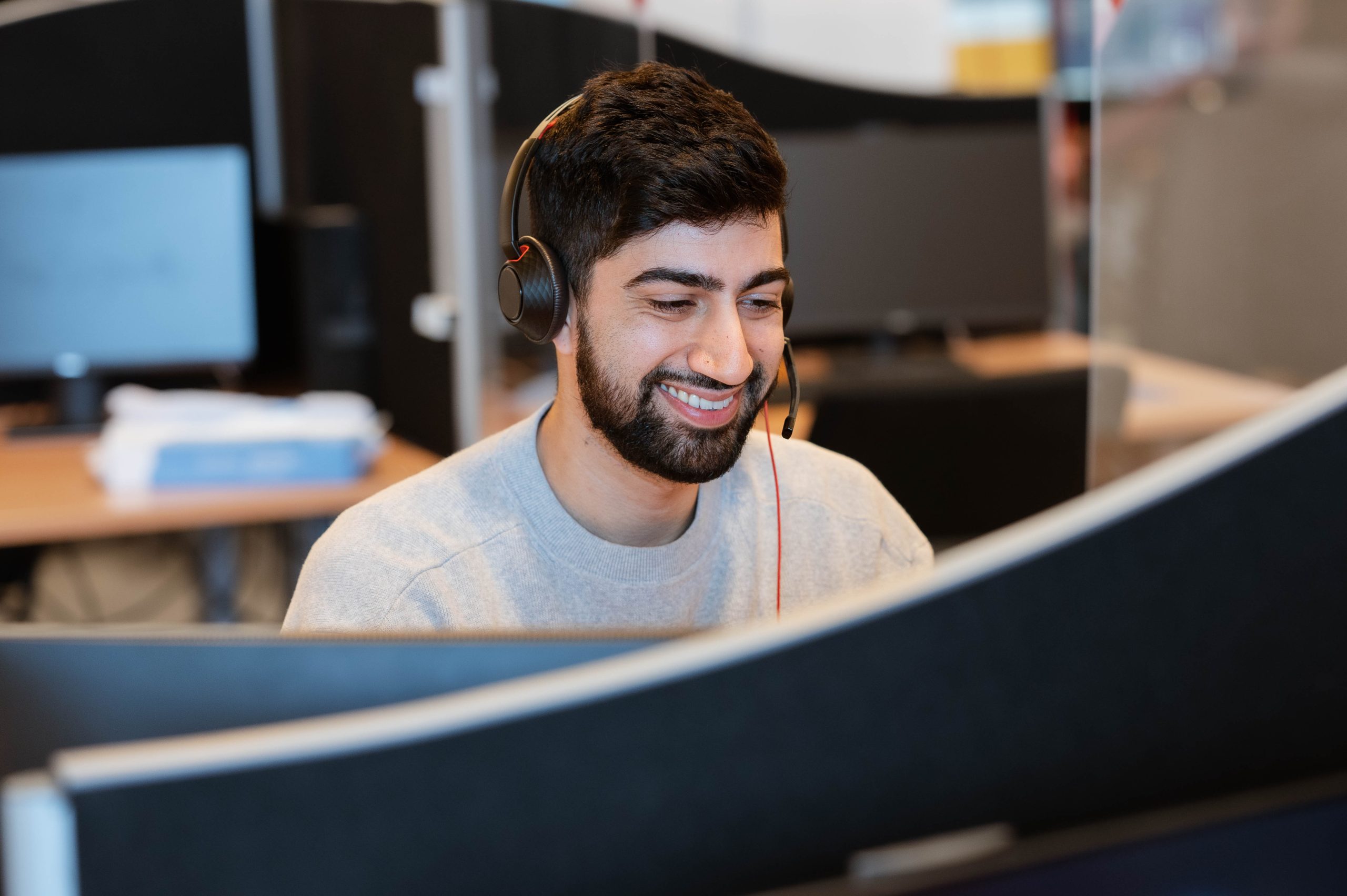 smiling guy with a microphone in a callcenter