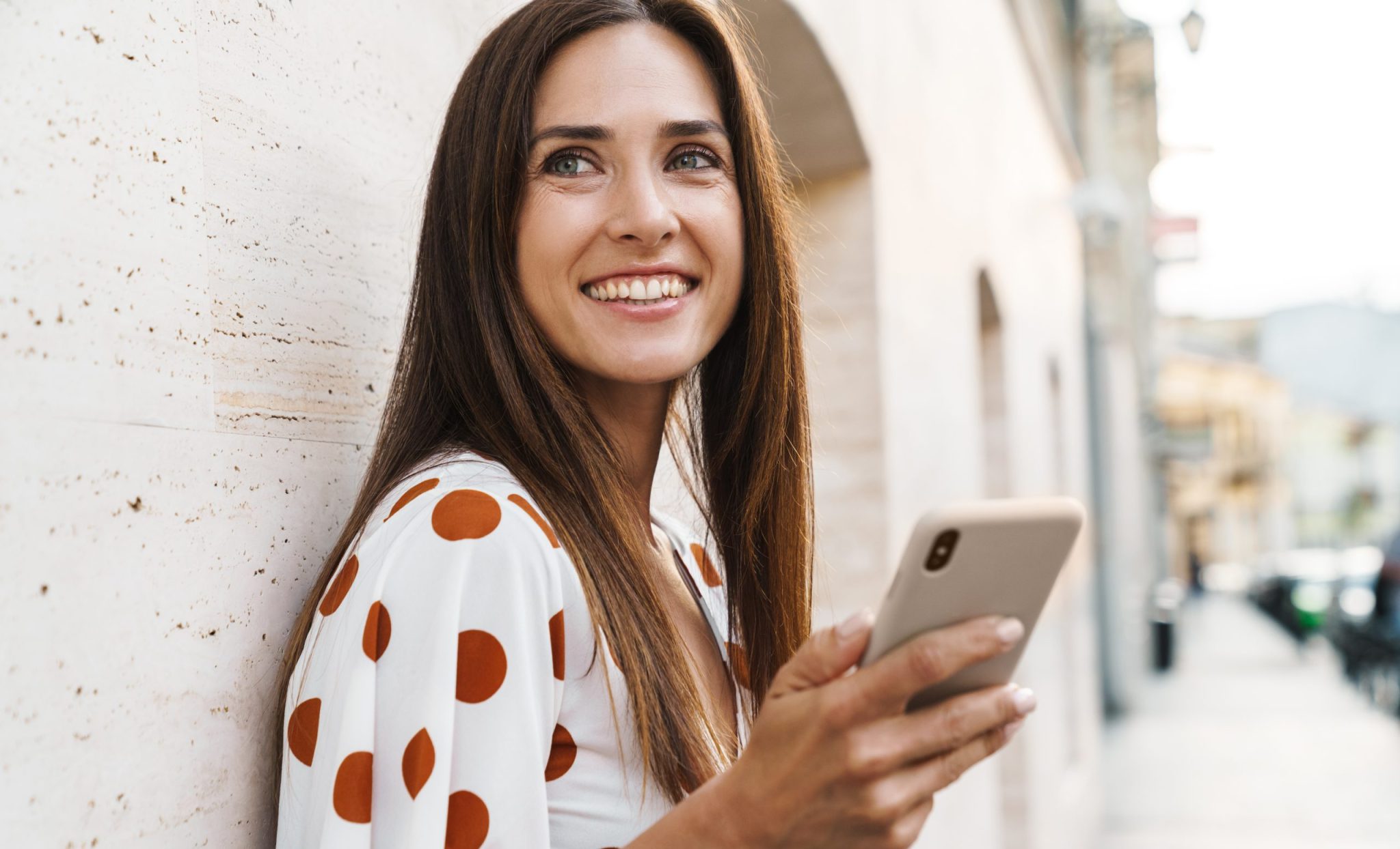 Vrouw lacht door menselijk klantcontact met smartphone in hand