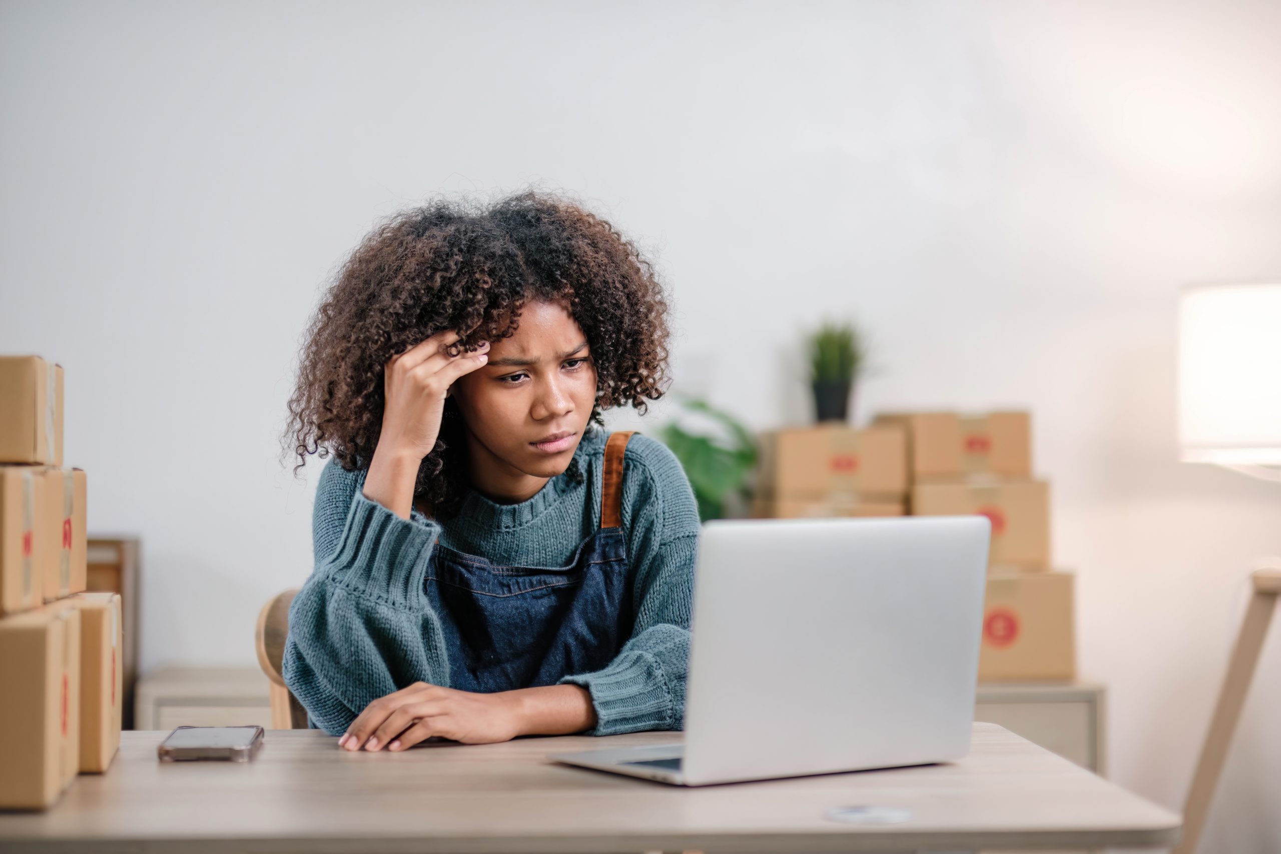 Thinking women looking at computer in an offshore contact center