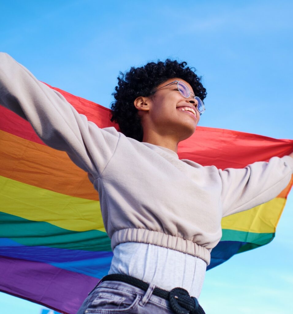 Woman celebrating LGBTQI+ Rights holding rainbow flag WEngage and ILGA Europe